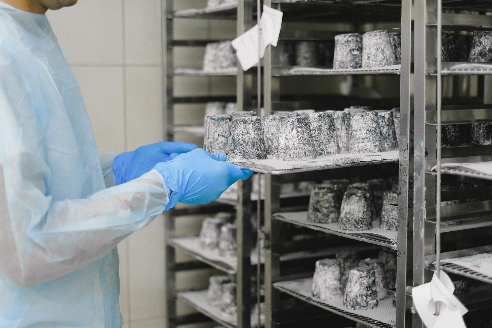 Шеф-повар на производстве проверяет качество готовой овощной продукции в светлом цеху с современным оборудованием